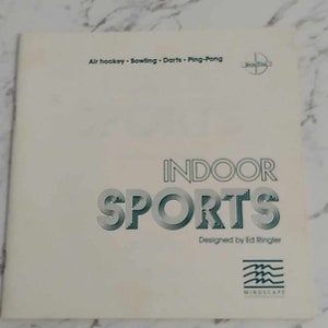 May include: A white booklet with a green and white title that reads "INDOOR SPORTS" designed by Ed Ringler. The booklet is for a game that includes air hockey, bowling, darts, and table tennis.
