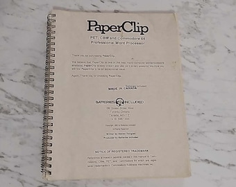 Könnte beinhalten: Ein weißes Handbuch für den professionellen Textverarbeitungs-Prozessor PaperClip für PET-, CBM- und Commodore 64-Computer. Das Handbuch gibt an, dass Batterien enthalten sind und es in Kanada hergestellt wurde.