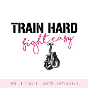 May include: A motivational graphic with the text "TRAIN HARD fight easy" in black and pink. Below the text are two black boxing gloves hanging by their laces. The image is on a white background.