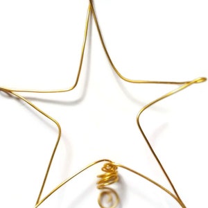 May include: A gold wire star ornament with a spiral wire at the bottom.