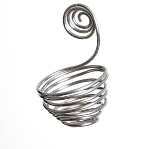 May include: A silver metal hanging basket shaped like a spiral. The basket is suspended from a thin string.