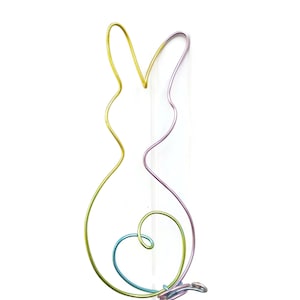 May include: A colorful wire sculpture of a rabbit with a heart shape in the center. The sculpture is made of multiple colors of wire, including yellow, green, blue, and purple.