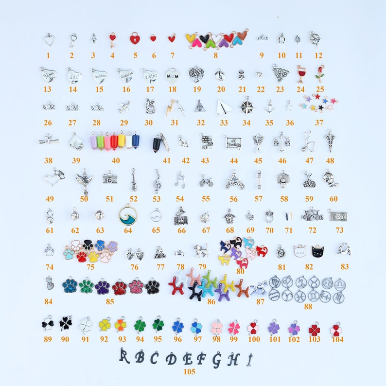 K&ouml;nnte beinhalten: Ein Set mit 105 silbernen und bunten Charms, nummeriert von 1 bis 105. Die Charms zeigen verschiedene Designs, darunter Herzen, Tiere, Noten und mehr. Die Charms sind in Reihen auf einem wei&szlig;en Hintergrund angeordnet.