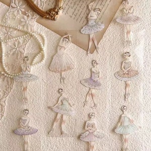 May include: A collection of delicate ballerina stickers in various poses and pastel colors, including pink, lavender, and mint green. Each sticker features a ballerina in a tutu, perfect for scrapbooking or crafting projects.