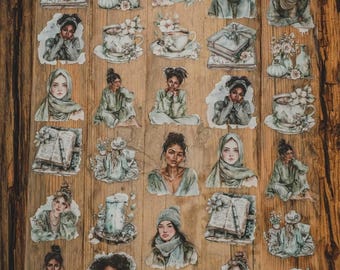 May include: A sheet of decorative stickers with watercolour illustrations of women, books, teacups, and floral arrangements in green, grey, and white. The stickers are arranged on a wooden surface.