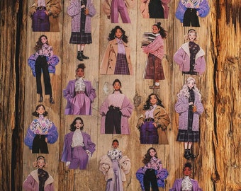 May include: A selection of fashion-themed stickers depicting illustrations of women in diverse stylish outfits. The stickers display a variety of colours, including purple, brown, and black, with detailed clothing designs and accessories. The stickers are arranged on a wooden surface.
