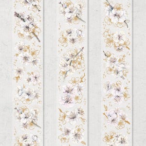 May include: Three strips of washi tape with watercolour illustrations of white cherry blossoms and gold accents. The floral designs include individual flowers and branches, with small starburst details.