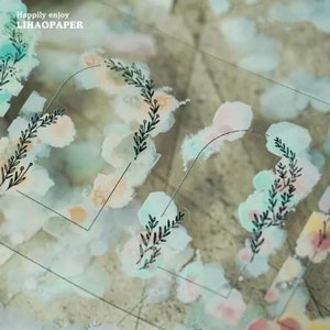 May include: Clear sticker sheet with watercolor-style pastel blobs in shades of pink, blue, and peach. Black line art of leafy sprigs and the text "Happily enjoy LIHAOPAPER" are also visible.