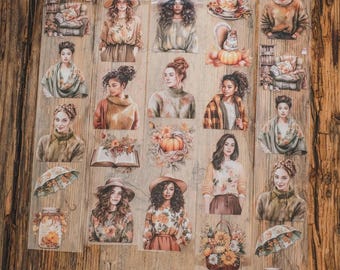 May include: A selection of transparent stickers depicting women in autumnal clothing, alongside fall-themed imagery such as pumpkins, flowers, and teacups. The stickers are displayed on a wooden surface, creating a warm, seasonal atmosphere.