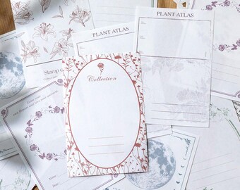 May include: A collection of decorative paper cards with floral and celestial designs. The cards feature botanical illustrations, the text "Collection", and the text "Plant Atlas". Some cards have lined spaces for notes. The color palette includes white, brown, and purple.
