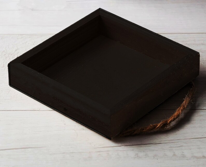 May include: A black wooden box with a rope handle. The box is empty and has a square shape.