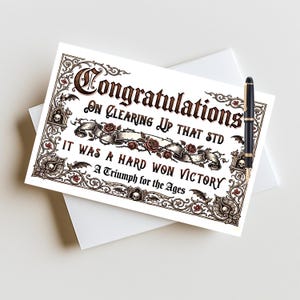 May include: A rectangular greeting card featuring the text Congratulations On Clearing Up That STD It Was A Hard Won Victory A Triumph for the Ages. The card has a dark ornate border with skulls, roses, and bats, and a black fountain pen.