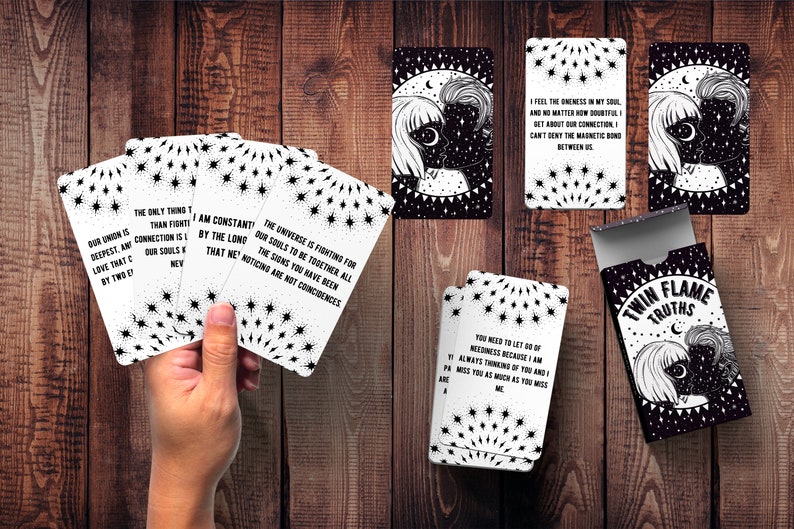 May include: A deck of black and white cards with the words "Twin Flame Truths" on the box. The cards feature black and white illustrations of a couple with stars and a crescent moon. The cards have quotes about twin flames, such as "The universe is fighting for our souls to be together. All the signs you have been noticing are not coincidences."