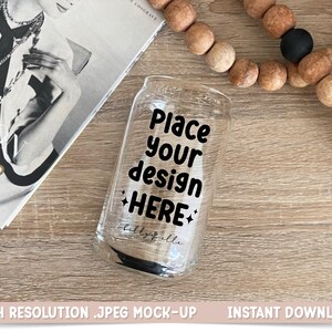 Puede incluir: Una lata de vidrio transparente con un diseño negro que dice "Place your design HERE". La lata está sobre una superficie de madera.