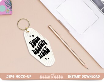 May include: White motel key chain with a gold ring. The keychain has the text "YOUR DESIGN HERE" in black, retro-style lettering.