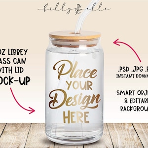 May include: Mockup of a 16 ounce glass can with a lid and a straw. The can is clear and has a gold design that says "Place Your Design Here".