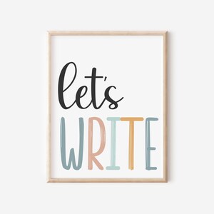 May include: A framed print with the text "Let's Write" in black script font. The word "Write" is in colorful, stylized lettering with shades of blue, pink, and yellow.