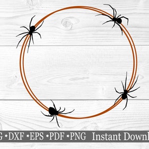 May include: A brown circle frame with four black spiders around the edge. The frame is on a white wood background.