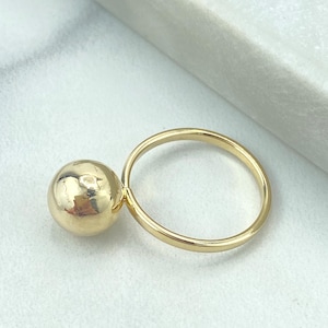 May include: A gold ring with a textured ball attached to the band.