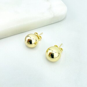 以下が含まれることがあります： 金色のボールスタッドイヤリングのペア。イヤリングはシンプルでエレガントで、あらゆる機会に最適なギフトになります。