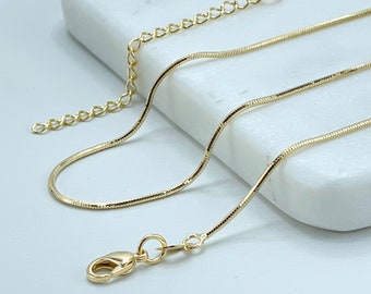 May include: A gold chain necklace with a lobster clasp closure. The chain is a thin, flat snake chain style.