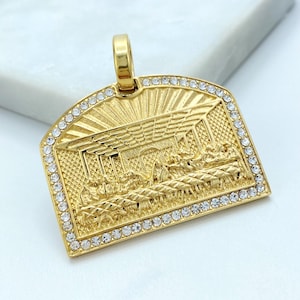 May include: Gold-coloured pendant depicting the Last Supper in relief. The rectangular pendant has a curved top and is edged with clear, round crystals. The bail is also gold-coloured. The pendant is a religious item.