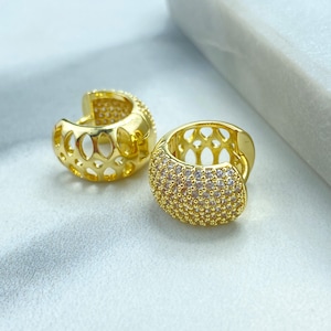 Puede incluir: Un par de pendientes de aro de oro, uno con un diseño delicado y calado y el otro con un engaste de pavé de pequeñas piedras transparentes.