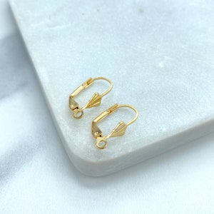 May include: Two gold-tone earring hooks with a fan-shaped design. The hooks are made of metal and have a spring-loaded clasp.