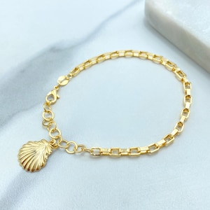 Peut inclure: Bracelet doré avec un charm en forme de coquillage. Le bracelet présente un design de chaîne à maillons rectangulaires et une fermeture à fermoir homard. Le charm coquillage est orné de rainures texturées.