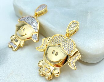 May include: Two gold-colored pendants in the shape of smiling children. The pendants have a shiny finish with clear, sparkling accents on the hair and clothing. The pendants are designed with a cheerful, cartoon-like aesthetic.