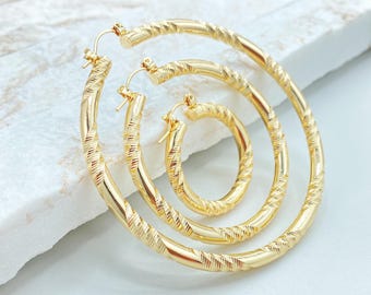 May include: Three gold-toned hoop earrings of varying sizes nested within each other. Each hoop features a continuous twisted, textured pattern along the entire circular band, with a simple hinged wire closure mechanism at the top of each earring.