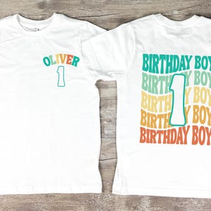 a white birthday shirt with the number one on it