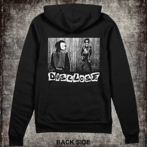 May include: Black hooded sweatshirt with a white graphic print of two figures and the word "DISCLOSE" on the back.