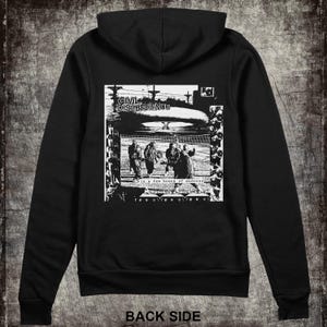 May include: Black hooded sweatshirt with a white graphic print of a band called "Civil Disobedience". The graphic features a band playing in front of a large, round object. The text "in a few hours of madness" is printed below the graphic.