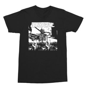 May include: Black t-shirt with a white graphic featuring a skeleton hanging from a chain, with the text "UNHOLY GRAVE" above. The design has a distressed, grunge aesthetic.