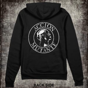May include: Black hooded sweatshirt with a white circle graphic on the back. The graphic features a stylized image of a person wearing a diving helmet and the text "ACCION MUTANTE".