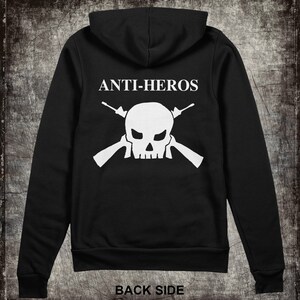 May include: Black hooded sweatshirt with a white skull and crossbones design and the text "ANTI-HEROS" on the back.