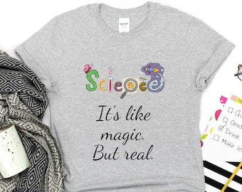 May include: Gray t-shirt with a colorful science themed graphic and the text "It's like magic. But real."