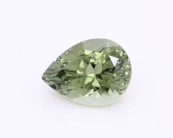 May include: A pear-shaped green gemstone with facets.