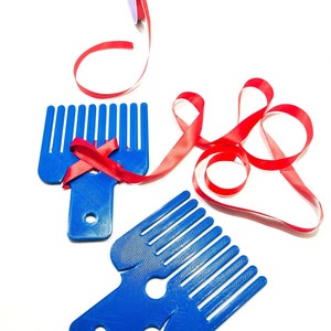 May include: Two blue plastic tools with comb-like teeth and a hole in the center. Red ribbon is wrapped around the top tool.