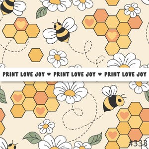 Könnte beinhalten: Ein sich wiederholendes Muster mit Bienen, Waben und Gänseblümchen auf cremefarbenem Hintergrund. Das Design enthält den Text "PRINT LOVE JOY" in einem weißen Banner. Die Waben haben Herzformen. Die Bienen sind schwarz und gelb.
