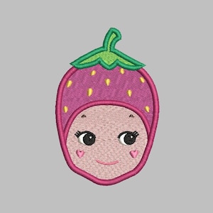 Pode incluir: Etiqueta bordada de um morango rosa com caule e folhas verdes. O morango tem um rosto sorridente com olhos castanhos e bochechas rosadas.