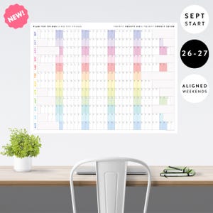 May include: A wall calendar titled PLAN THE THINGS // DO THE THINGS for the years TWENTY TWENTY SIX / TWENTY TWENTY SEVEN. The grid features a vertical list of months from September to August with color-coded columns and aligned weekends.