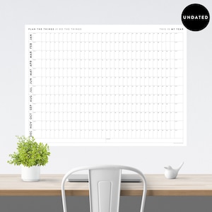 May include: A black and white printable wall calendar with the text "Plan the things // Do the things" and "This is my year". The calendar is undated and has a grid layout with spaces for each day of the year.