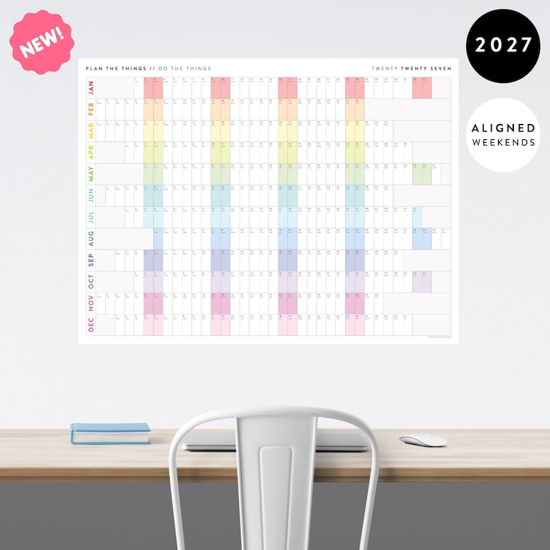 May include: A 2027 wall calendar featuring a horizontal grid layout with months listed vertically in rainbow colours. The header reads PLAN THE THINGS // DO THE THINGS and TWENTY TWENTY SEVEN. It includes a pink NEW badge and a white ALIGNED WEEKENDS circle.