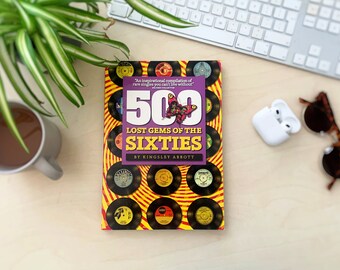 May include: A purple book titled "500 Lost Gems of the Sixties" by Kingsley Abbott. The cover features a colourful butterfly and a pattern of vintage vinyl records.