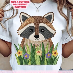 May include: White t-shirt with a raccoon design in brown, grey, and tan patches, set against green grass and flowers. The text on the shirt says "NOT A CUTTING OR SEWING PATTERN" and "DIGITAL DOWNLOAD - NOT A PHYSICAL ITEM."