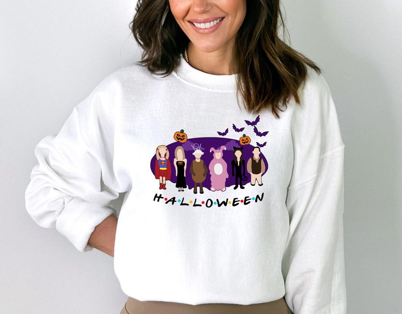 May include: White sweatshirt featuring a purple graphic of the characters from the TV show "Friends" dressed in Halloween costumes. The graphic includes the text "H.A.L.L.O.W.E.E.N."