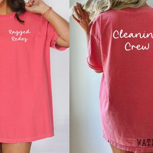 May include: A pink oversized t-shirt with the text "Ragged Redos" on the front and "Cleaning Crew" on the back.