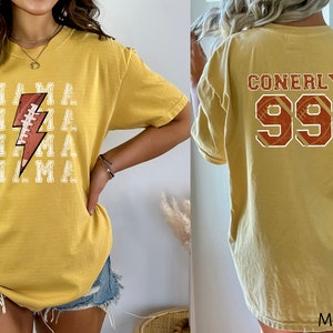 May include: A mustard yellow t-shirt with a football and lightning bolt graphic on the front and the text "CONERLY 99" on the back.